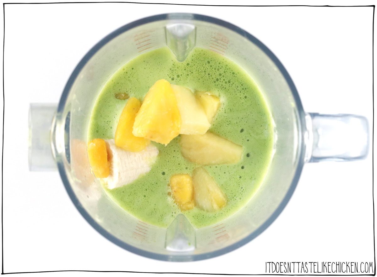 Add the banana, frozen mango, and frozen pineapple to the blender. Blend until green smoothie is smooth and creamy.