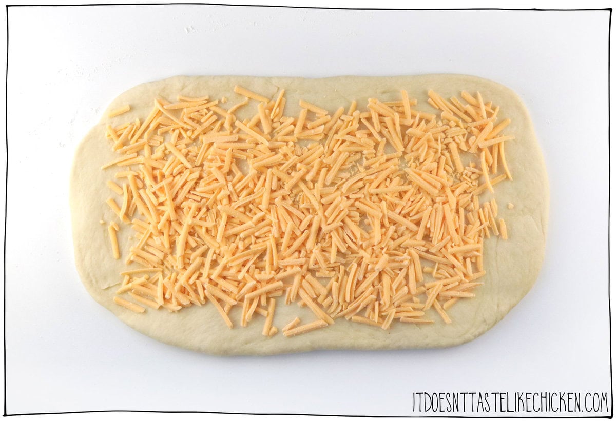 Roll out the dough and scatter the cheese on top.