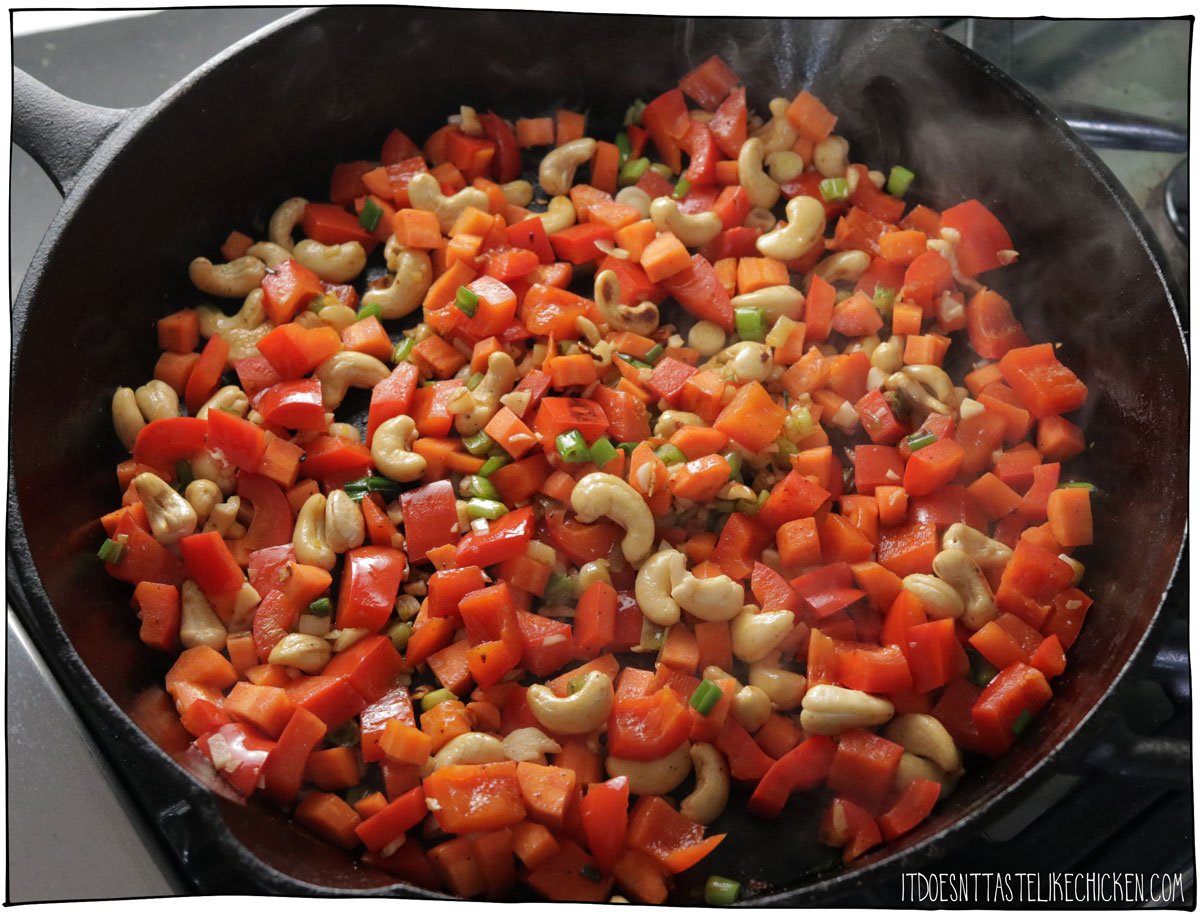 Return the skillet to the stove over medium-high heat. Heat the light oil, then add the red pepper, carrot, white and light green parts of the green onions (reserve the dark green parts for later), cashews, and garlic. Sauté, stirring often, until the vegetables just begin to soften and brown, about 5 minutes. Sprinkle with curry powder and cumin, and cook for 1 minute until fragrant.