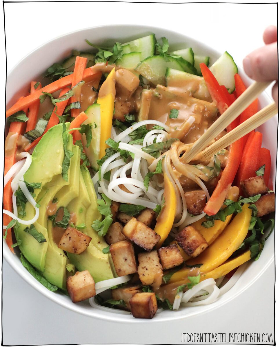 This recipe tastes just like the Vietnamese cold spring rolls, but disassembled in a bowl! Skip the fiddly wrappers and make a Vegan Spring Roll in a Bowl instead! This fresh, healthy, flavor-packed bowl is a complete meal and can be whipped up in just 30 minutes.  Seasoned tofu cubes, hot or cold rice noodles, fresh veg with mango and avocado, a ton of fresh herbs (this is the key to irresistible flavor), all drizzled in delicious peanut sauce.